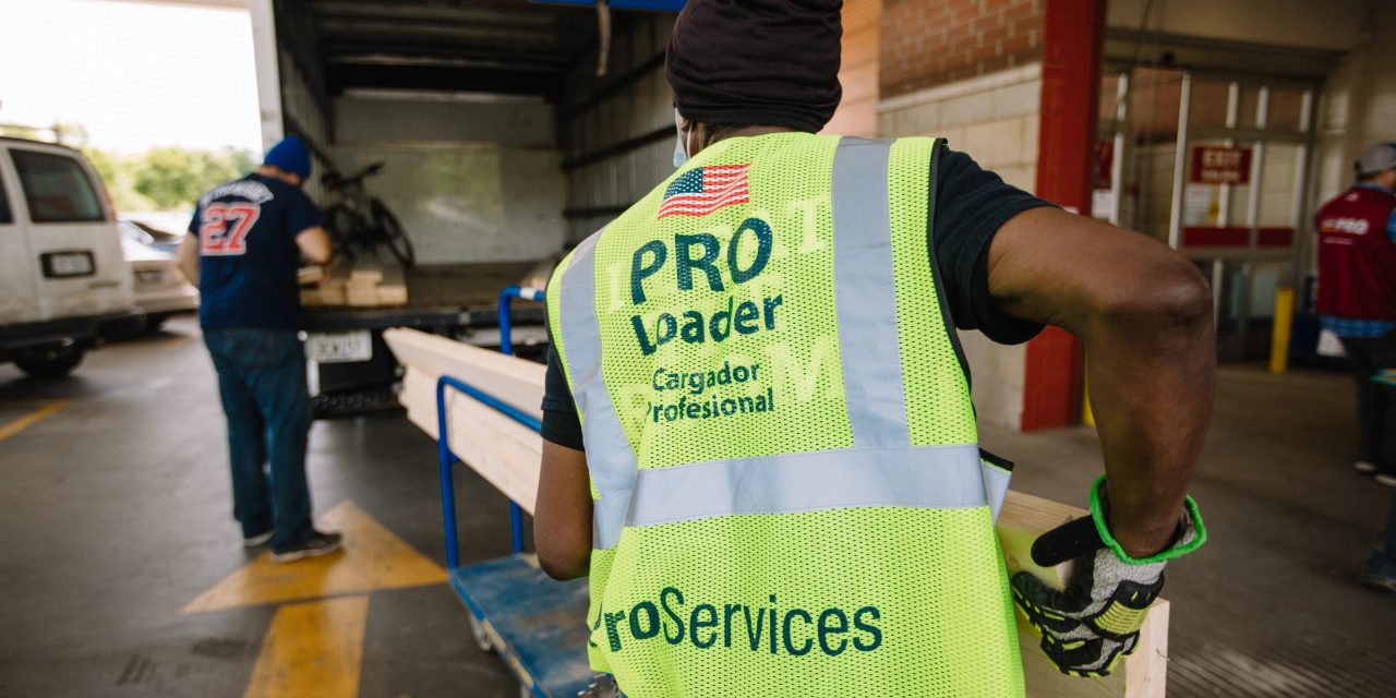 The header photograph features a person with a yellow vest loading construction materials into a truck.