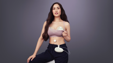 Photograph of a woman using an Elvie breast pump.