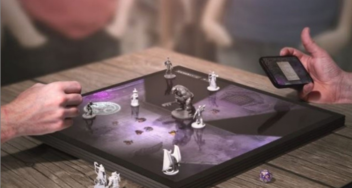 Photograph of people sitting around playing chess on a digital game board.