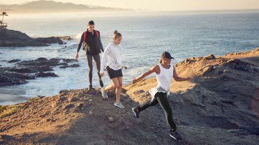 The lead image shows three people hiking in Athleta x REI clothing.