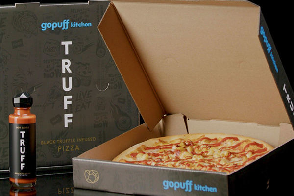 Pizza in a Gopuff labeled-box topped with Truff hot sauce