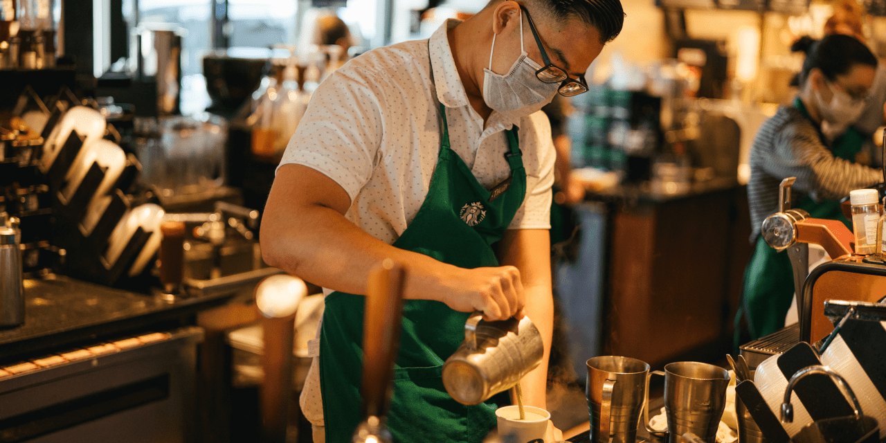 Starbucks worker mixes up a coffee drink