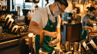 Starbucks worker mixes up a coffee drink