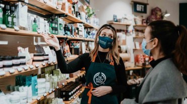 Employee showing off soap and other products at the Body Shop