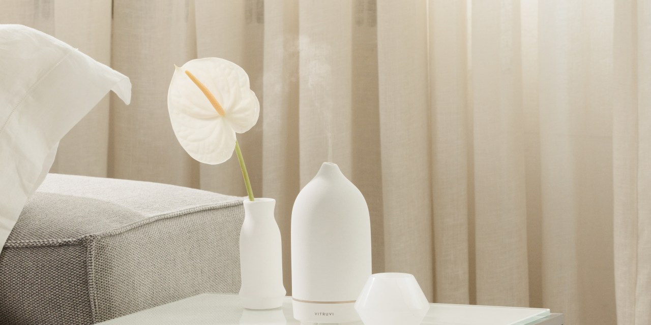 A white Vitruvi diffuser on a side table