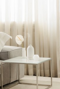 A white Vitruvi diffuser on a side table