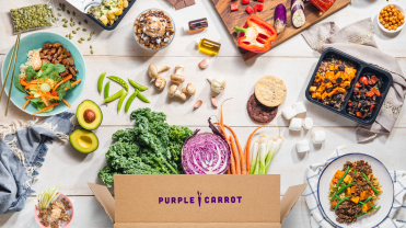 Meal kit box from purple carrot with vegetables like green cale, purple cabbage and orange carrots