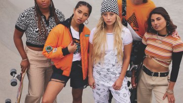 People in a skatepark holding skateboards while modeling orange-colored streetwear