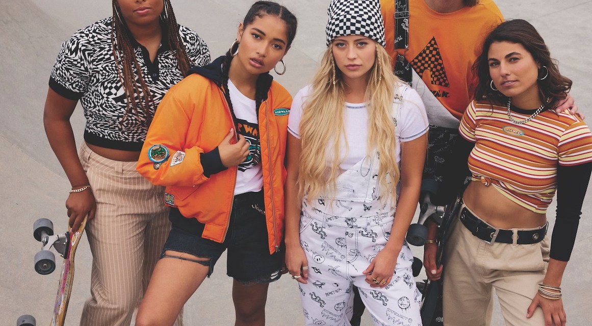 People in a skatepark holding skateboards while modeling orange-colored streetwear