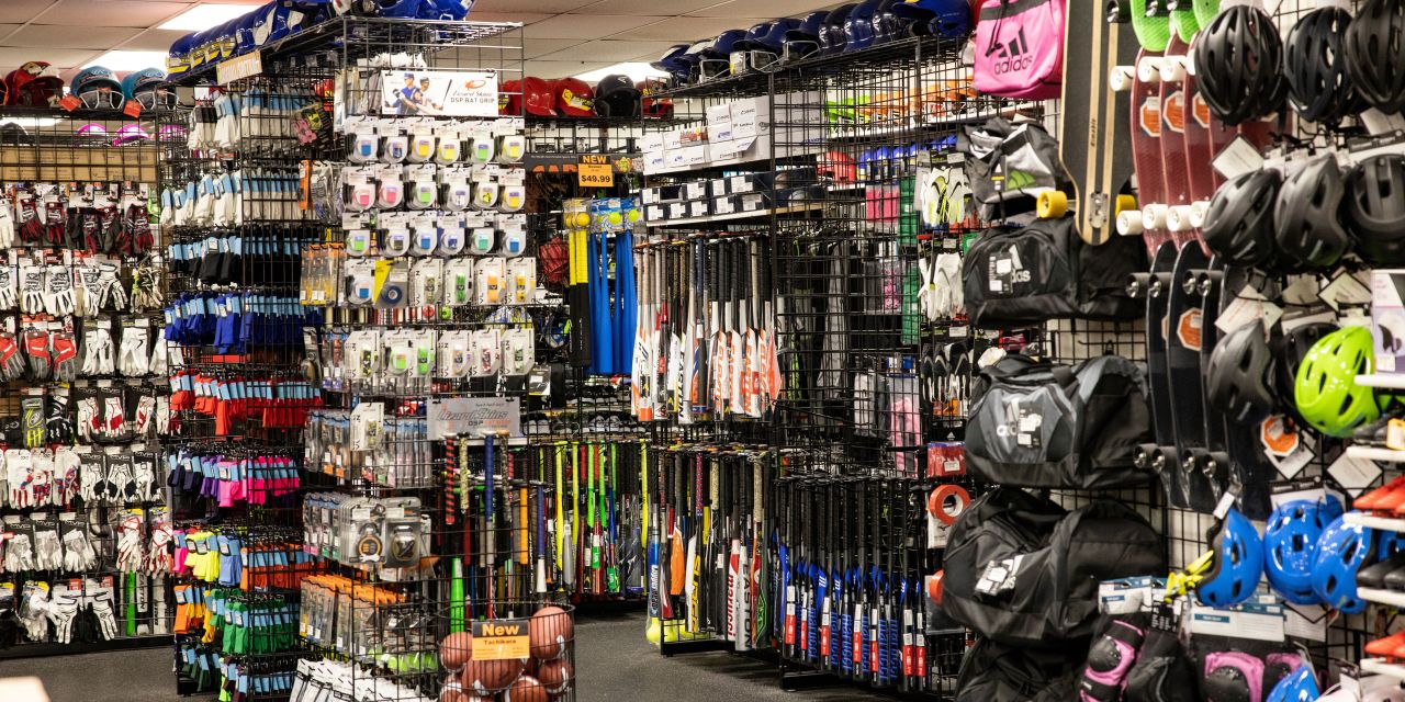 An aisle of helmets, bats and sports gear in a store