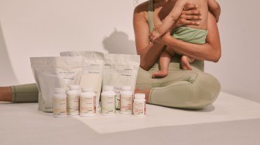 Needed's prenatal vitamin assortment with a mother and child in the background.