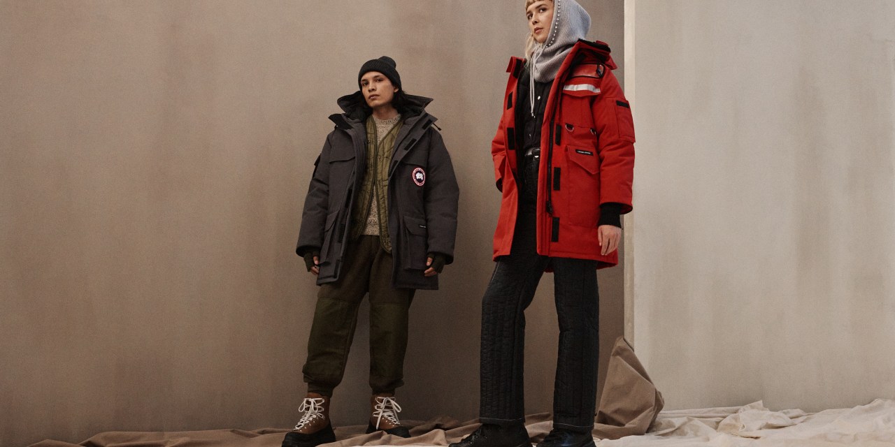 Two models wearing black and red Canada Goose jackets.