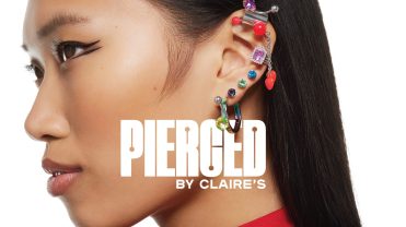 A woman stands sideways with her left ear showing a variety of piercings.