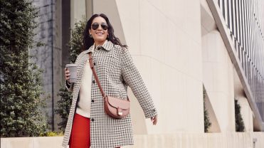 Woman wearing Macy's private label clothes walks down the street