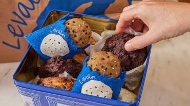 Levain cookies and ornaments in a tin box.