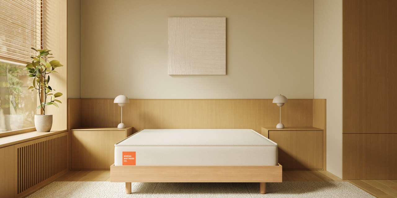 White mattress on a tan platform in a neutral-colored bedroom