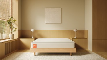White mattress on a tan platform in a neutral-colored bedroom