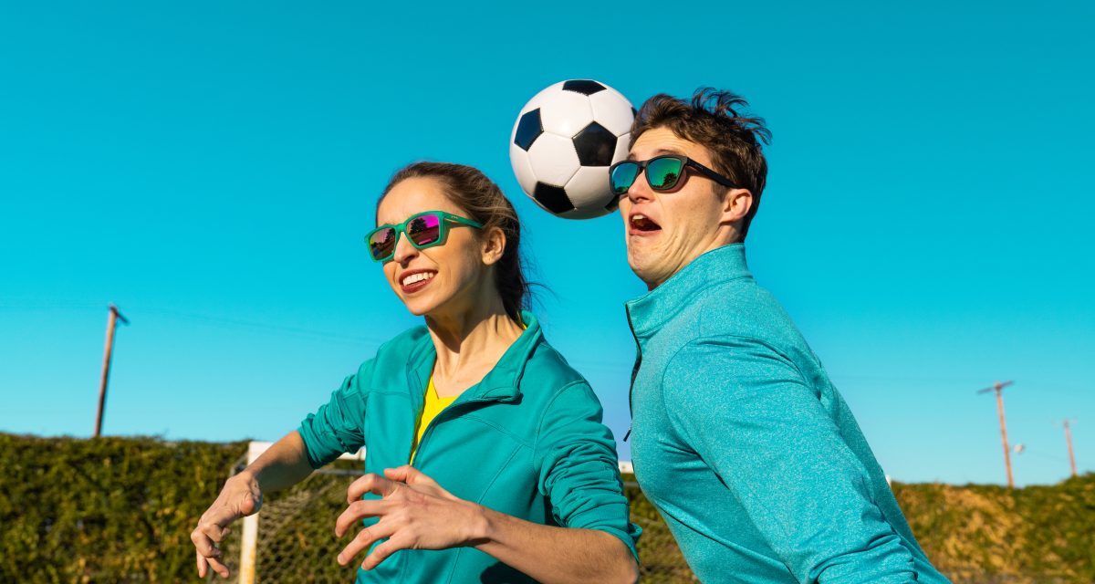 Two people playing soccer while wearing Goodr sunglasses.