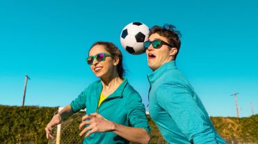 Two people playing soccer while wearing Goodr sunglasses.
