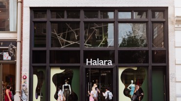 Photo of a store entrance with a sign that says Halara as pedestrians walk by on a busy sidewalk.