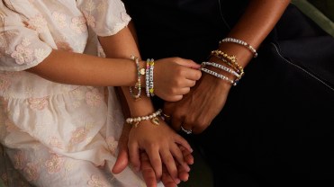 Models holding hands wearing charm bracelets