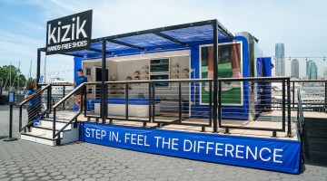 A blue Kizik trailer showing racks of shoes
