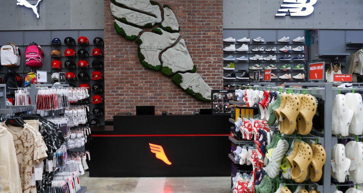 Rows of shows next to a mural in a footwear store.