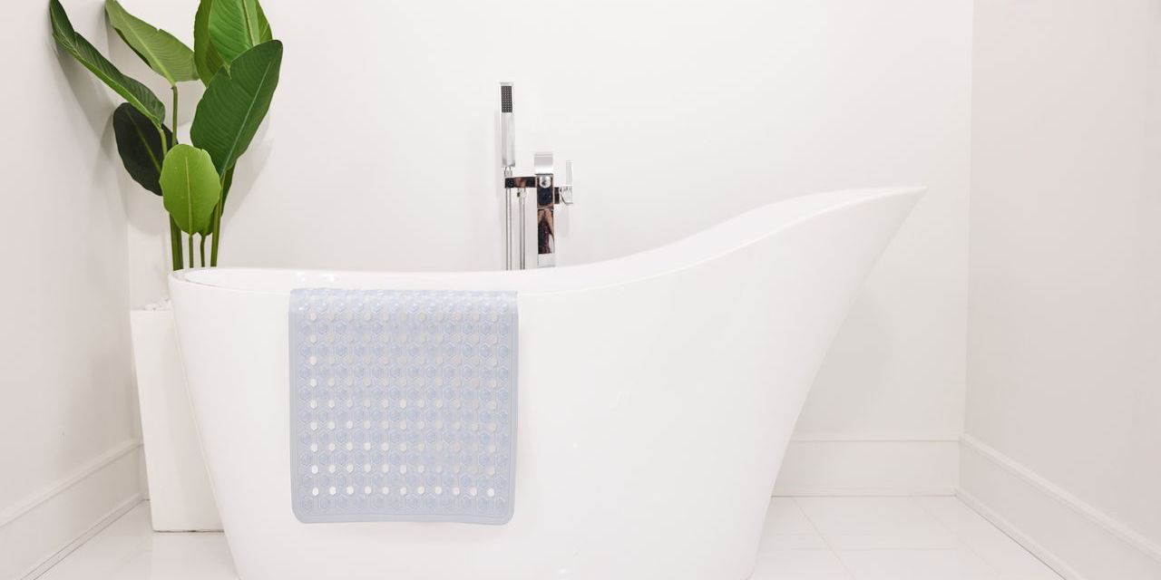 Silicon bath bat draped against a white bath tub